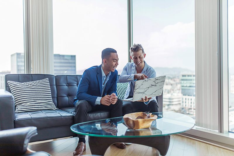 two men discussing finances on couch