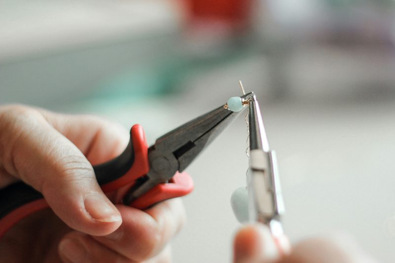 person making beaded jewelry