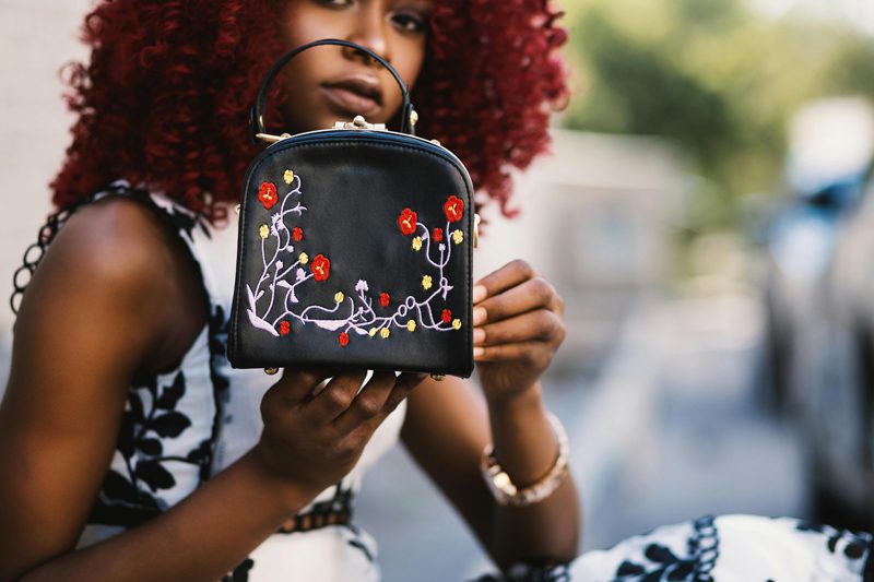 woman holding embroidered purse