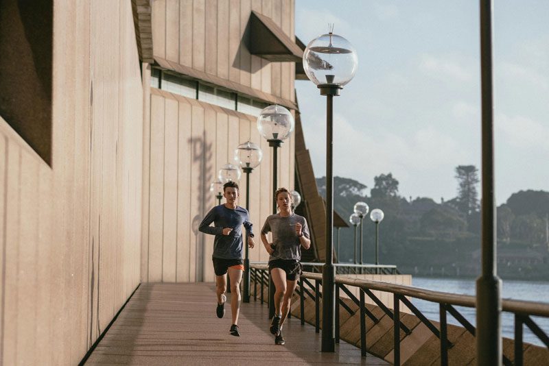 couple jogging along water