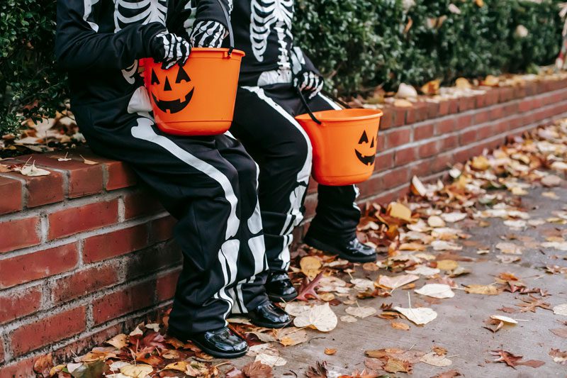 kids sitting in skeleton costumes