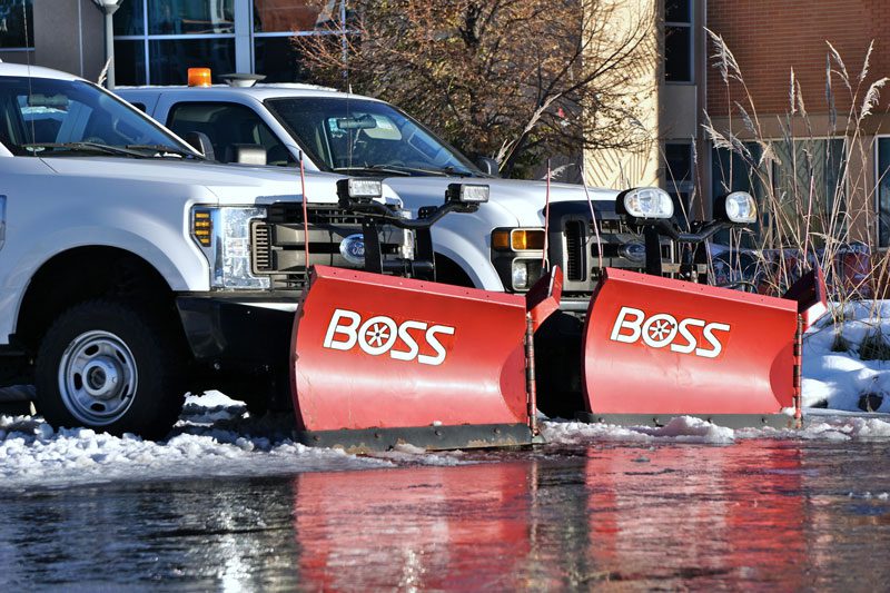 snow plow trucks parked in lot