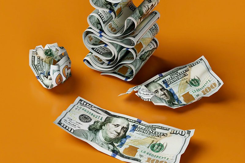 100 dollar bills on orange background