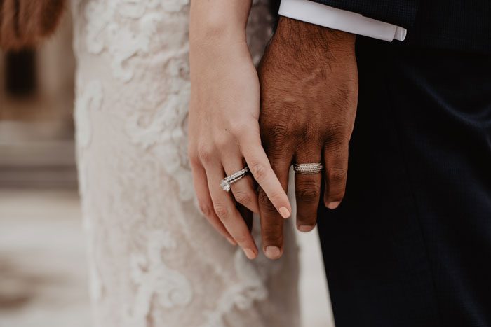 couples' hands with wedding bands