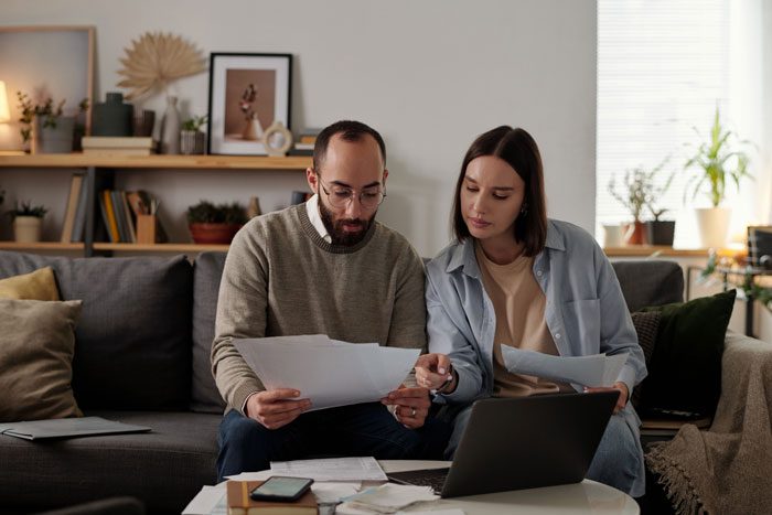 couple sitting on couch planning budget