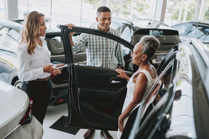 people shopping at a car dealership