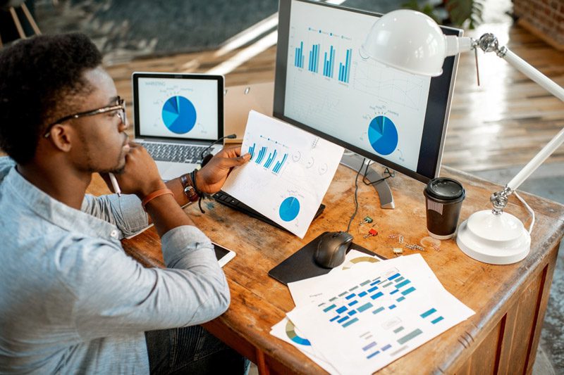 data scientist seated at desk reviewing graphs