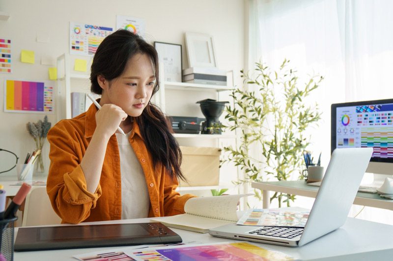 young woman doing graphic design in home office