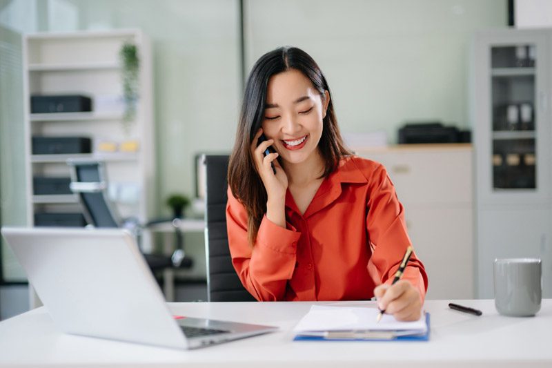 woman smiling while answering a phone call