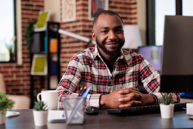 man smiling at his desk
